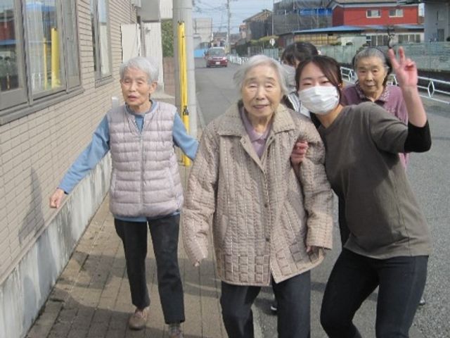 笑顔の散歩風景 お散歩 スタッフが明るい笑顔でサポートする姿が印象的です。共に楽しむ時間がやりがいの一つとなっています。