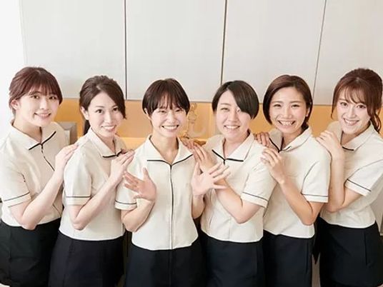 笑顔のスタッフたちが並ぶロビー  