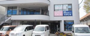 送迎車が並ぶ建物外観