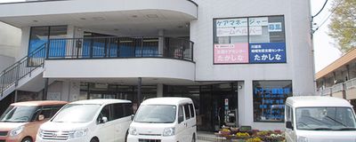 送迎車が並ぶ建物外観