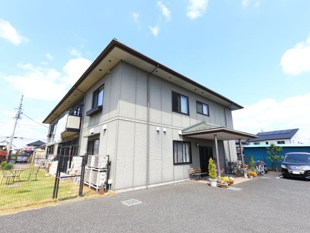 晴れた日の清潔な外観 外観 晴れた日差しに輝く、落ち着いた色合いの建物です。駐輪スペースも備え、清潔感が感じられます。