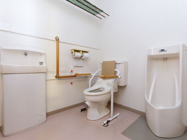 バリアフリー設計のトイレ 共用トイレ 手すり付きのトイレは、安心してお使いいただけるよう配慮された設計です。利用者の移動や支援がしやすい空間です。