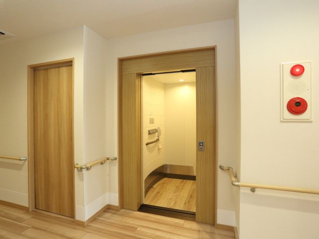 明るいトイレのドア エレベーター すべての壁に手すりが設置され、無駄のないシンプルなデザインで、安全に配慮されたトイレです。