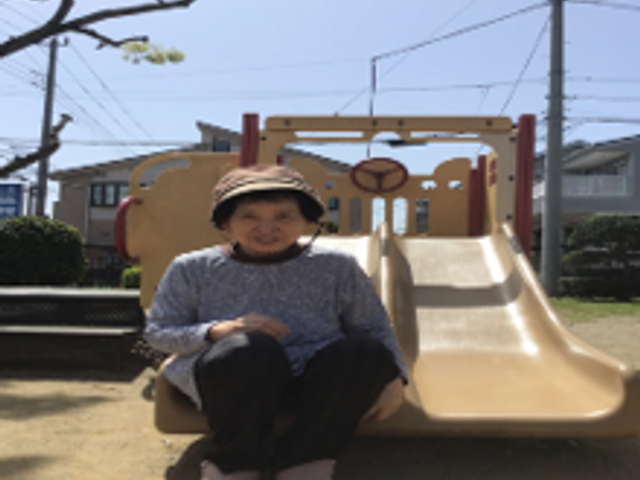 笑顔の利用者と遊具 日常 日差しを感じる中庭で、安らぎながらベンチに座る利用者の姿が見られます。お天気の良い日には戸外で穏やかな時間を過ごせます。