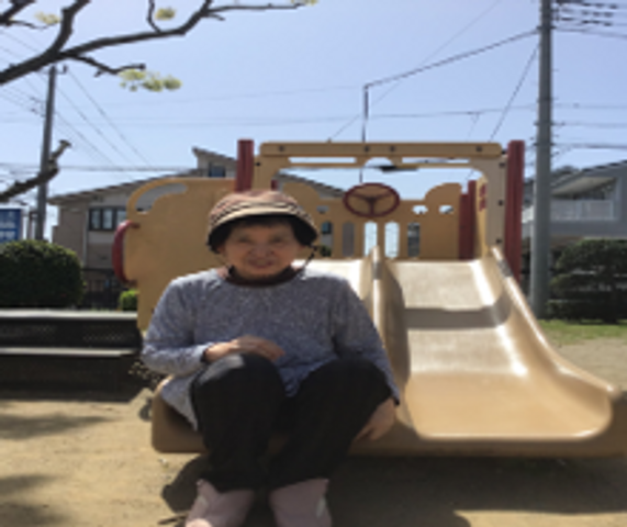 笑顔の利用者と遊具 日常 日差しを感じる中庭で、安らぎながらベンチに座る利用者の姿が見られます。お天気の良い日には戸外で穏やかな時間を過ごせます。