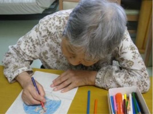 お絵かきする高齢の女性