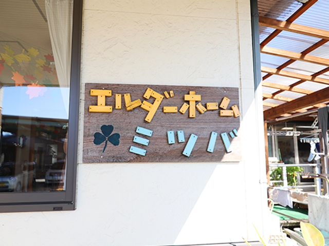 温かな雰囲気の看板 看板 やさしい色合いの看板が設置されたエントランスは、来訪者をほっとさせる空間です。