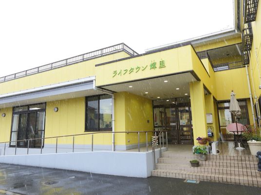 黄色い外観の建物エントランス