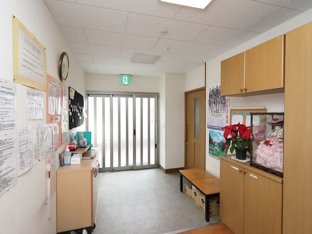 明るいエントランスの様子 玄関 清潔感のある入口付近です。情報の掲示や季節の花が飾られ、温かみのある雰囲気を醸し出しています。