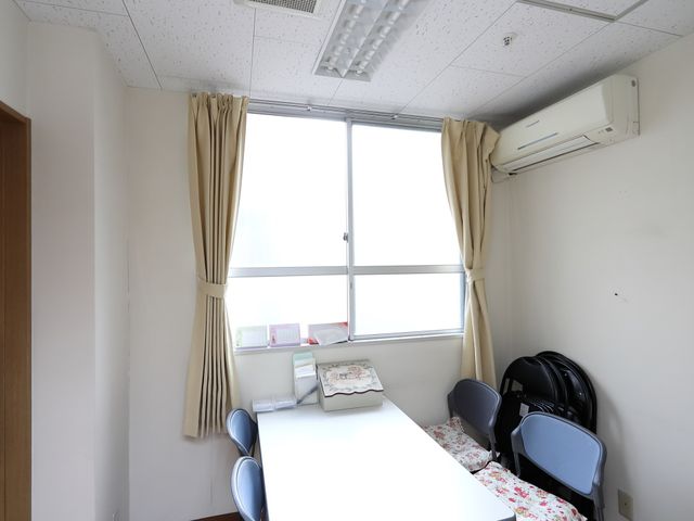 居室のテーブルと椅子 談話室 清潔感のある個室です。日当たりが良く、テーブルでの読書や作業に適しています。