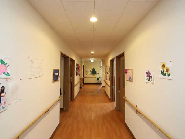 廊下に飾られたアート 廊下 壁に飾られた色とりどりのアート作品が明るい雰囲気を醸し出し、温かみを感じさせる通路です。ゆったりとした空間で働くことができます。