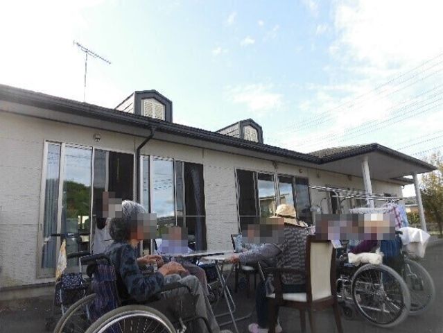 テラスで憩う人々 日常風景 温かな日差しを感じながらくつろぐ方々の姿が印象的です。ゆったりとした時間が流れる場所です。