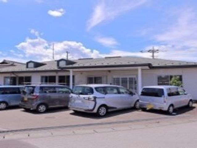 青空と施設の外観 外観 青空が広がる中、車が並ぶ建物前です。快適な環境での仕事に興味はありませんか？