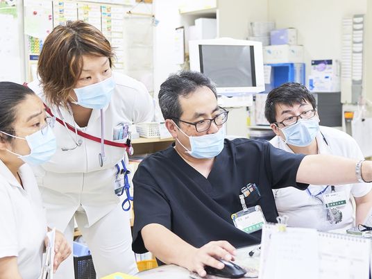 職員が相談する事務室  