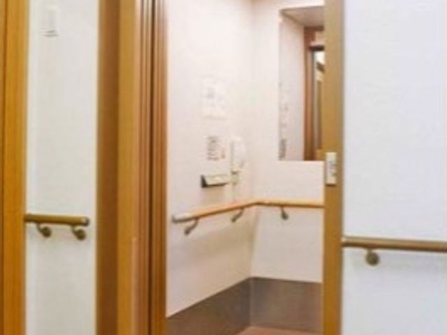 手すり付きの開放的な廊下 エレベーター 手すりが整備された廊下はゆったりとしており、安心して歩行することができます。レイアウトは利用者様の快適さを考慮した設計です。