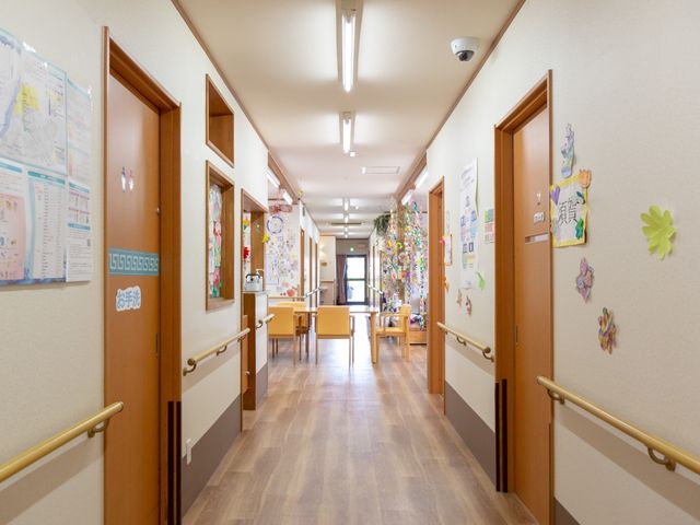 廊下の温かい雰囲気 廊下 手すりがしっかりと設置された廊下は、壁に飾られた手作りのアートで心温まる空間になっています。お一人でも安心して移動ができる設計です。