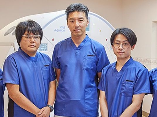 制服のスタッフが並ぶ室内  