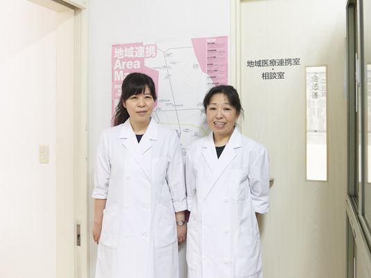 白衣の職員が並ぶ相談室  