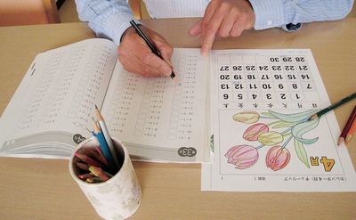 人が机で学習している様子