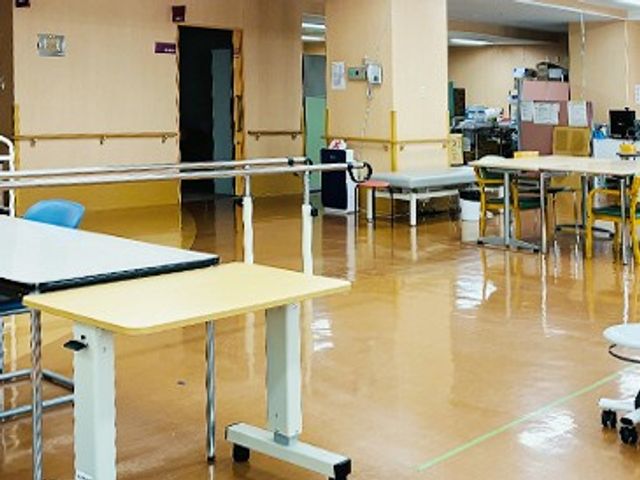 明るい機能訓練室 機能訓練室   手すりが設置された広い空間に、訓練用の机や器具が整っています。動きやすさに配慮した環境で、日々のリハビリに使いやすそうです。