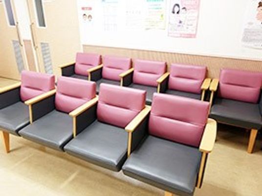 ピンクの椅子が並ぶ待合室  