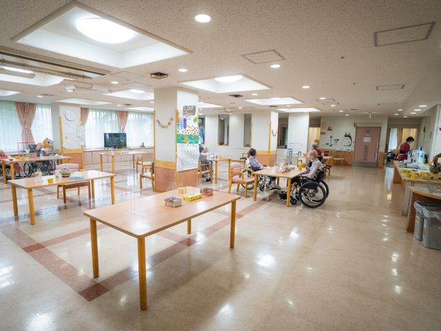 広々とした共有スペース ラウンジ ゆったりとした空間で、車椅子の方々も快適に過ごせます。スタッフと利用者が和やかに交流しています。
