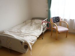 明るい居室のベッドと椅子