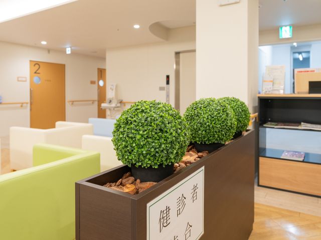 明るい受付ロビー ロビー   受付カウンターのある明るいロビーです。観葉植物やソファが置かれ、落ち着いて過ごしやすい印象です。