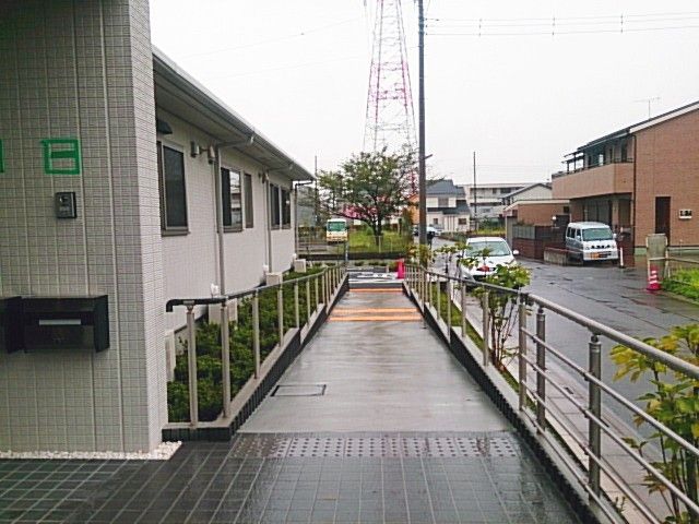 雨の日の外観 外観 広々とした屋外スペースには、車椅子でも安心できるスロープがあります。清潔で整った訪問エリアです。