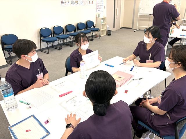 研修中の職員たちの多目的室 多目的室 白いテーブルを囲んで職員同士が話し合う、研修に使いやすい落ち着いた空間です。椅子が並び、打ち合わせや学びの場として活用しやすそうです。