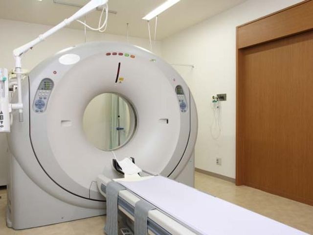 検査機器のある室内 内観   大型の検査機器が置かれた、清潔感のある明るい空間です。広めの出入口が見え、動線に配慮されたつくりに見えます。