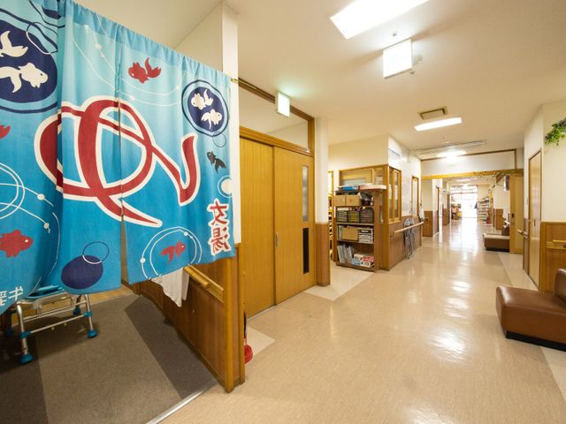 廊下の和風のれん 廊下 廊下には和風のれんがかかり、温かみを感じさせるデザインで皆さんの心地よい毎日をサポートします。ゆったりとした通路が、ゆとりのある環境を提供しています。