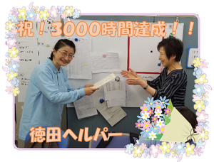 掲示物前のスタッフ  