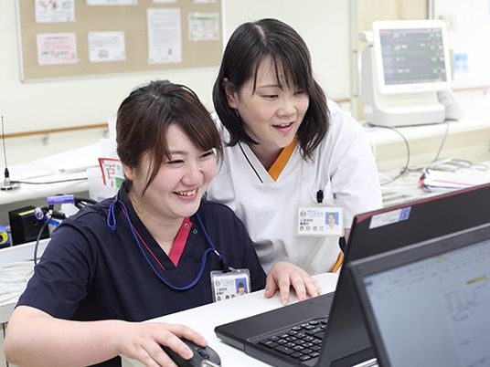 スタッフがパソコン確認する休憩室  