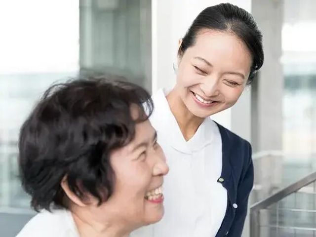 笑顔のスタッフと利用者の交流 内観   スタッフと利用者の方が笑顔で会話しており、親しみやすい雰囲気が伝わります。明るい空間で、働く様子をイメージしやすいです。