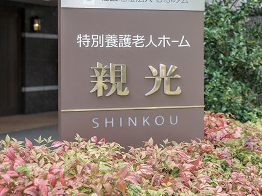 施設の看板と植え込みの外観  