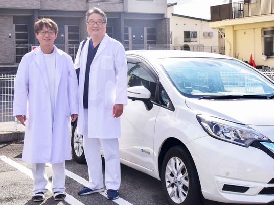 白衣の男性2人と車の外観  