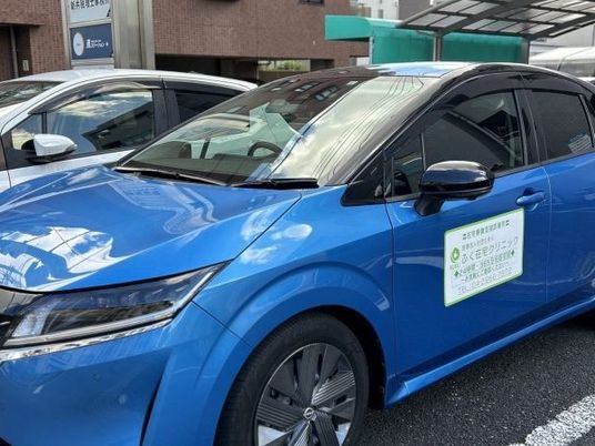 青い送迎車と建物前  