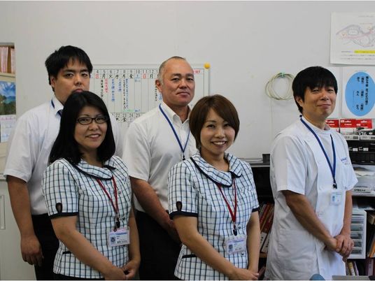 スタッフが並ぶ事務室  
