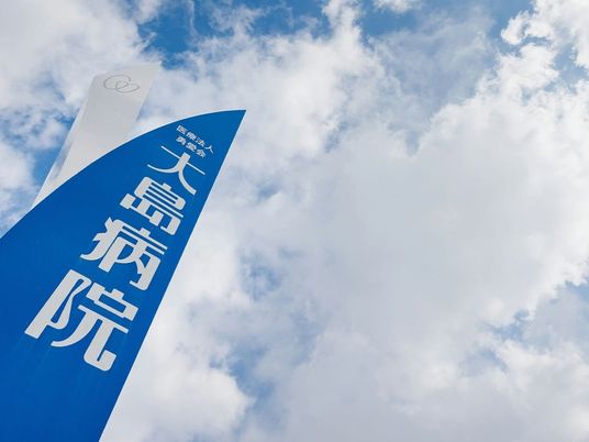 病院名の看板が空に映える外観  