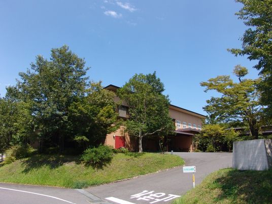 緑に囲まれた建物の外観  