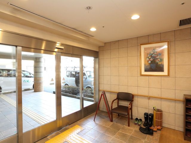 エントランスの明るい空間 玄関 スタッフと来訪者が出迎えられるエントランスは、優しい光が差し込む、温かみのある待ち合わせ場所です。