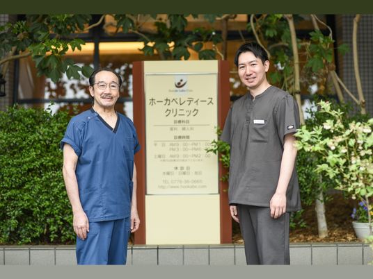 制服姿の職員が並ぶ玄関前  
