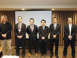 スーツ姿の男性が並ぶ室内  