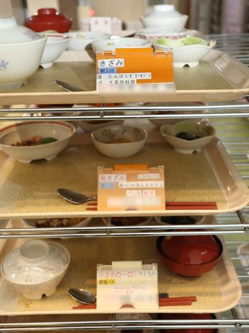 食堂の食器棚 食事 各種の食事オプションが並べられた温かみのある食堂です。細やかな配慮が感じられる食事の提供で、ご利用者様の毎日が豊かになります。