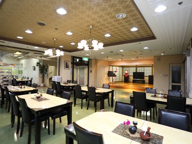 広々とした食堂空間 共有スペース 和洋を兼ね備えたダイニングルームです。ゆったりとした食事や憩いの時間を提供しており、背もたれ付きの椅子が配置されています。
