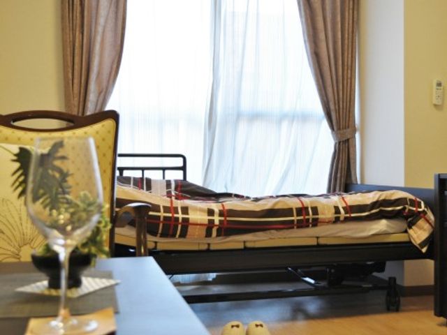 快適なベッドのある居室 居室２ 明るく居心地の良い居室です。日々の休息に適した落ち着いた空間で、快適な生活を支えます。