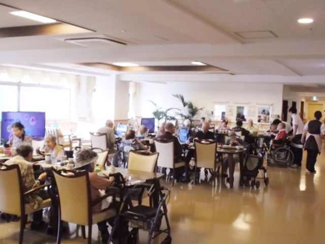 共有スペースでのひととき 食堂 明るく広々とした食堂で、入居者が食事や交流を楽しんでいます。車椅子の方も快適に過ごせる設計になっています。