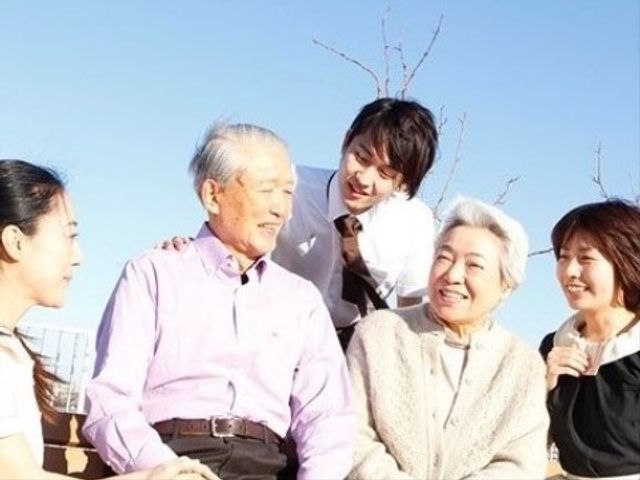 笑顔の集合晴れた空の下 環境３ スタッフと利用者の和やかな対話のひととき。明るい表情で会話を楽しんでいます。