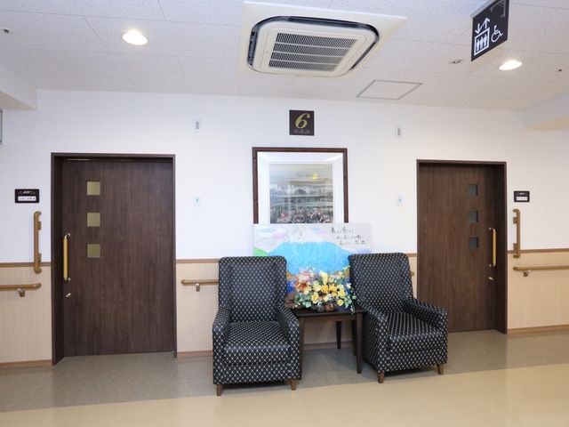 廊下の椅子と花 ロビー 花々で彩られた安らぐ休憩スペースです。廊下にある快適な椅子は、ひとときのくつろぎに最適です。